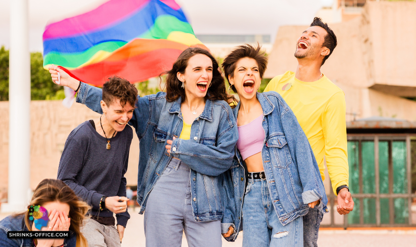 Exuberant group of friends laughing with a rainbow flag in the background, embodying support in coming out to parents in a post about how to come out to your parents